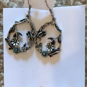 Silver earrings with flowers and leaves in it